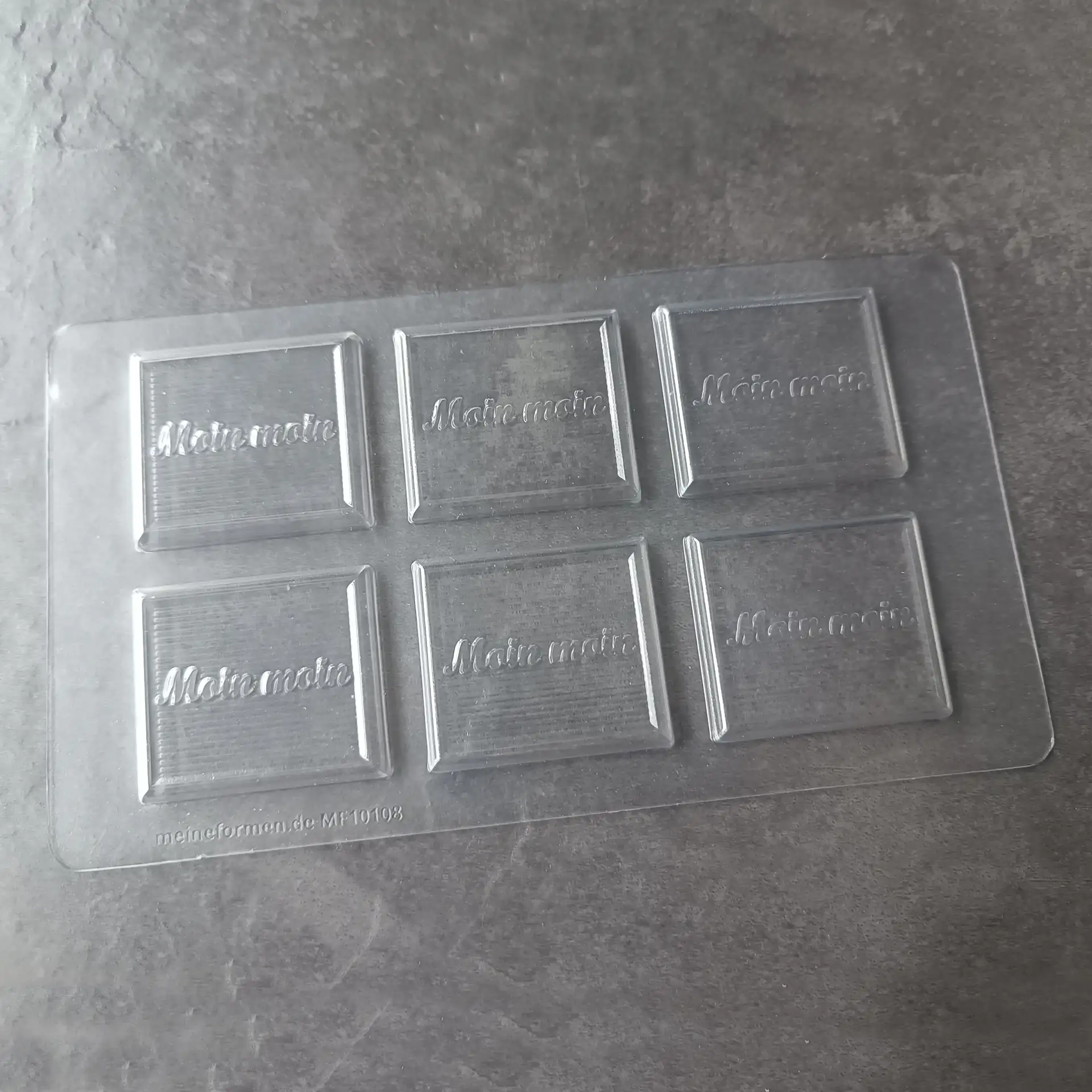 Mould for small chocolate tablets with the inscription ‘Moin moin’ in German
