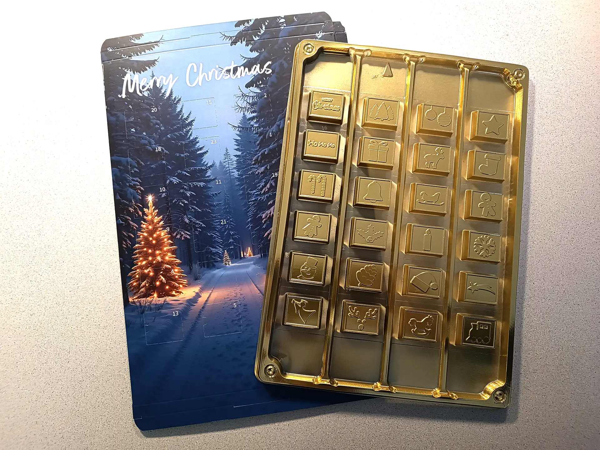 Adventskalender zum Selbstbefüllen mit Blister-Einlage für 24 Schokoladenstücke, verschneiter Wald mit beleuchteten Weihnachtsbäumen