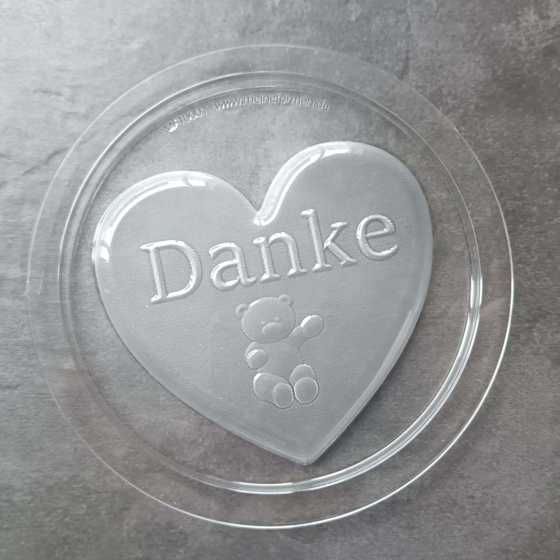 Schokoladenform für Herzen mit dem Schriftzug "Danke" und einem Teddybär
